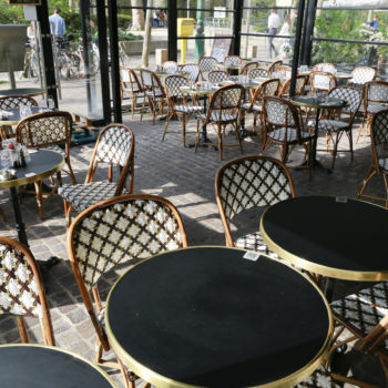 Restaurant parisien avec sa superbe terrasse composée de chaises en rotin et tables bistrot